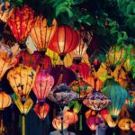 a bunch of lanterns that are hanging from a tree
